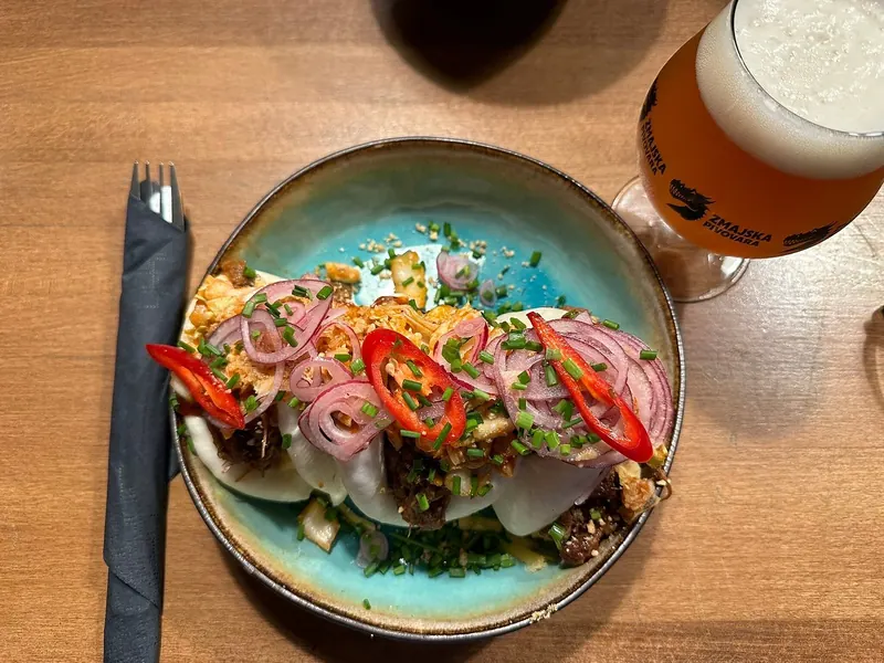 Bao buns with pickled onion and chili next to a beer